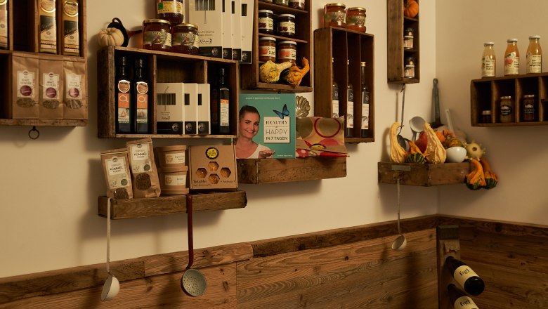 Enjoyment MEISTEREI Heiligeneich, © Philipp Monihart – www.charakter.photos Shelves with food and cooking utensils on a wooden wall.