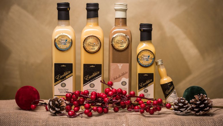 Abhof Höfinger products, © Fotografiehoch2, Richarda Kunzl Bottles of egg liqueur and chocolate liqueur on jute with decoration.