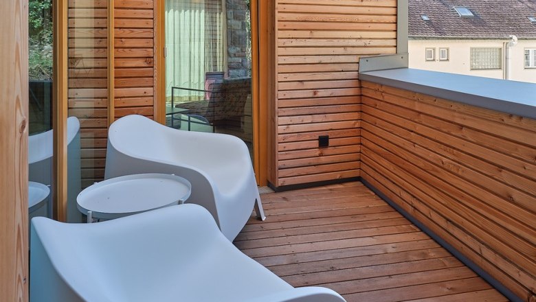 House Five Balcony, © Prof. Arch. DI Dietmar Kraus Modern balcony with wooden walls and white chairs.