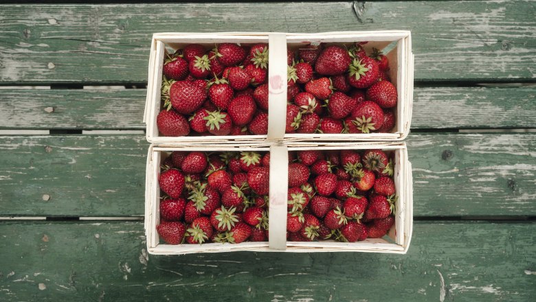 Strawberries, © Iam Ehm �� friendship.is DSCF1488 Two baskets of fresh strawberries on a green wooden table.