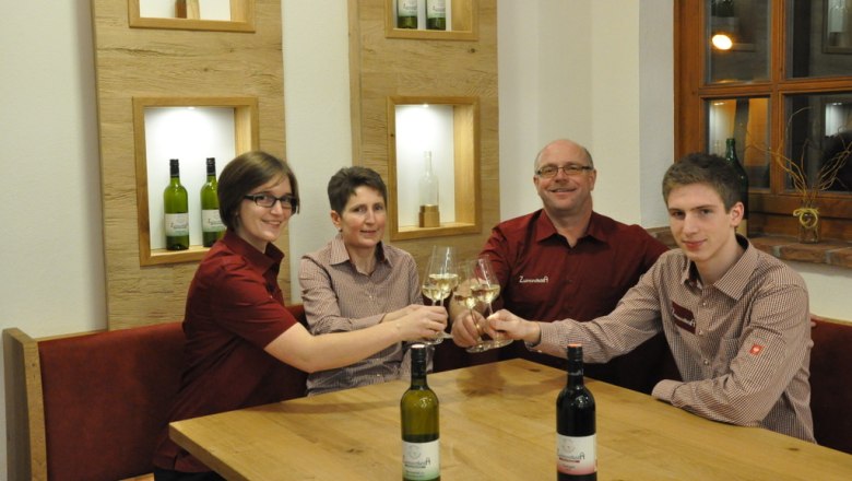 Eberhart family, © Markus Brückler Four people clink glasses of wine at a table.