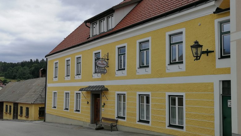 Gasthof Enne, © Roman Zöchlinger Yellow building with the inscription 'Gasthof Enne' and a Zwettler beer sign.
