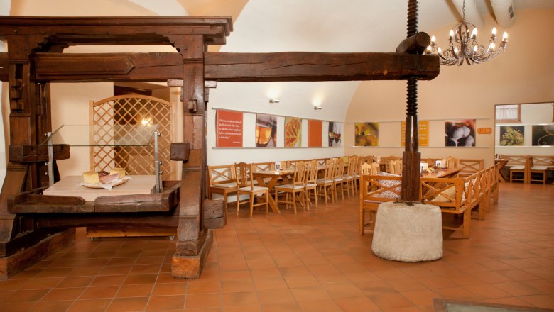 Althofheuriger, © Althof Retz Interior view of a traditional wine tavern with wooden furniture and an old wine press.