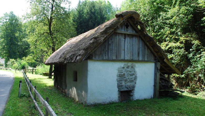 Dörrhaus, © Schager Peter A traditional thatched cottage in a rural setting, surrounded by trees and meadows.