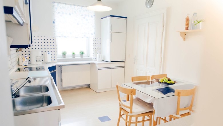 Apartment & guest room "Vino Verde", © Fam. Willmann Bright kitchen with dining table, chairs and modern appliances.