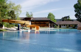 Waldbad Markt Piesting, © Isabella Palfy An outdoor pool with slide and buildings in the background.