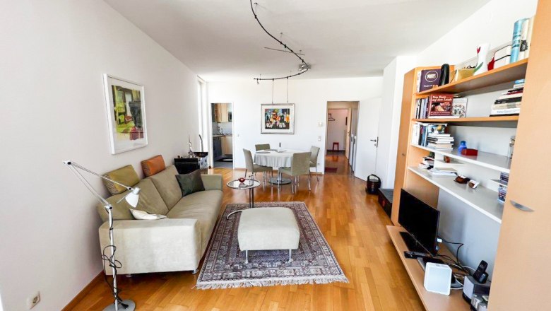 Apartment at the city park, © Apartment am Stadtpark Modern furnished living room with sofa, carpet, dining table and bookshelf.