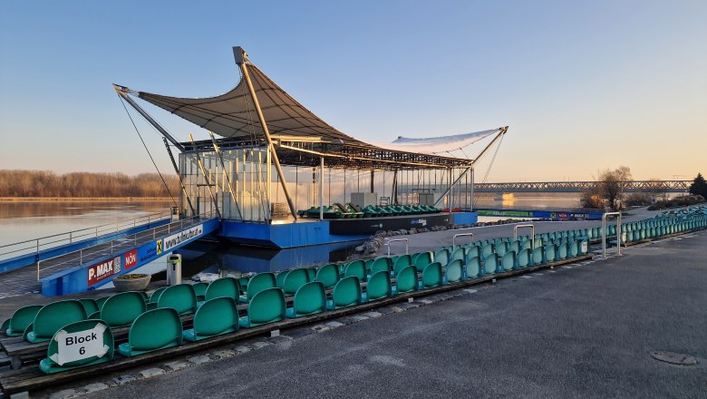 Danube stage in winter, © Donau Niederösterreich, K.Kancer Open-air stage with empty rows of seats on the riverbank at sunrise.
