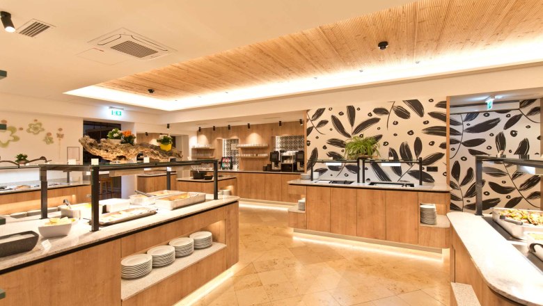 Flack Wirt - Buffet area, © Daniel Fischer Modern buffet area with wooden decor and plants.