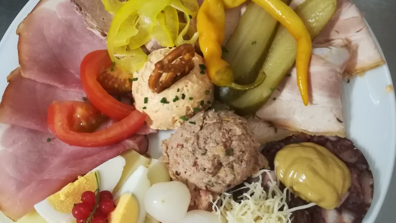 heurigenjause-family-resch-1, © Familie Resch A plate with various types of sausage and cheese, eggs, onions, peppers and spreads.