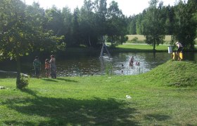 Natural bathing pond St. Martin, © Marktgemeinde St. Martin People bathing in a natural pond surrounded by trees and meadows.