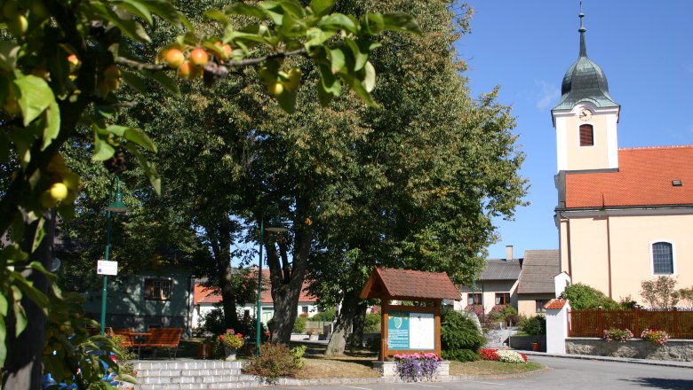 Eggern, © Eggern Village square with church, trees and information board in Eggern.
