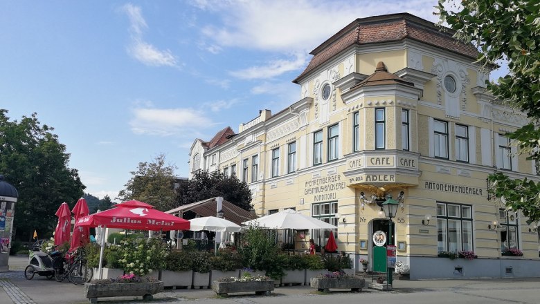 Restaurant Ehrenberger, © Roman Zöchlinger Historic building with café and terrace, surrounded by parasols and plants.