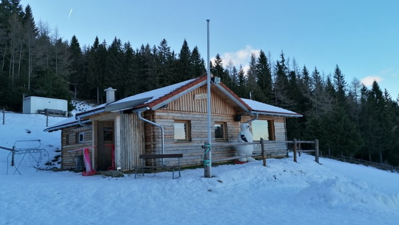 Sumpihittn #2, © Wiener Alpen Klikovics A wooden hut in the snow in front of a forest.