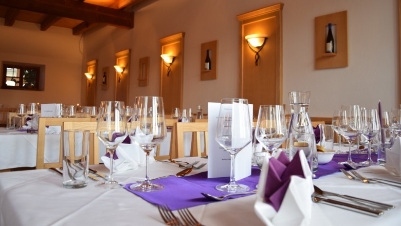 Culinarium, © Gessl Elegant restaurant with laid tables, wine glasses and purple napkins.