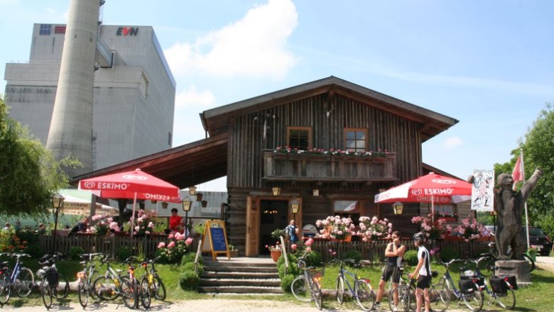 Bärndorfer huts, © Familie Scharl Wooden hut with terrace, bicycles and parasols in front of an industrial building.
