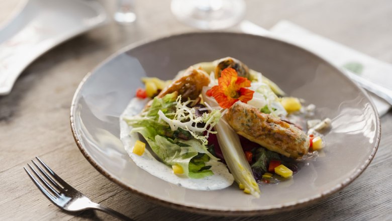 Regional spring rolls, © Niederösterreich Werbung/Michael Reidinger A plate with spring rolls, salad and edible flowers.