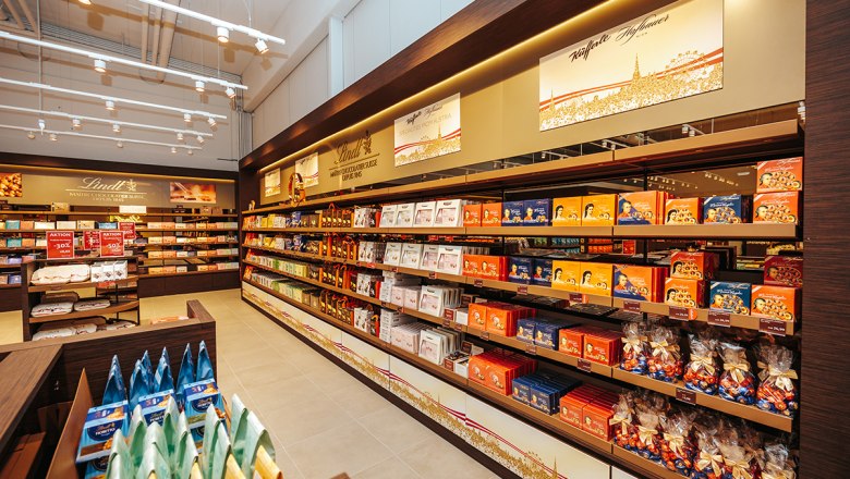 Lindt & Sprüngli Shop, © Philipp Lipiarski Interior view of a Lindt & Sprüngli store with shelves full of chocolate and sweets.