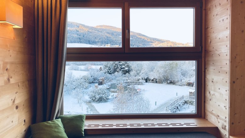 Forest dream window, © Peter Pichler View from a wooden window of a snowy landscape with mountains in the background.