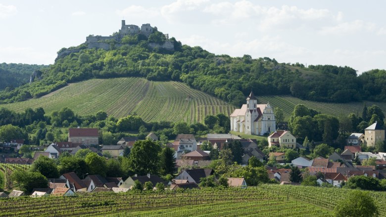 Falkenstein, © Michael Himml View of the Falkenstein castle ruins on a hill, surrounded by vineyards and a village with a church.
