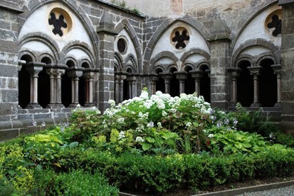 Cloister, © Reinhard Mandl A medieval cloister with round arches and a central garden with flowers and shrubs.