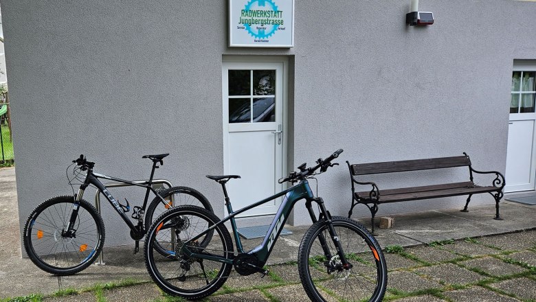 Kastner bike workshop, © Kastner Two bicycles in front of a workshop with the sign 'Radwerkstatt Jungbergstrasse'.