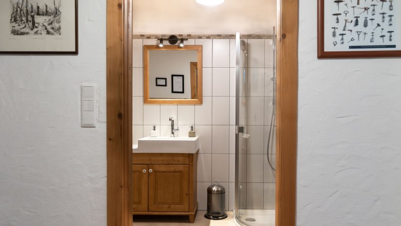 Bathroom with shower, © Weinakademie Retz View through a door to a bathroom with shower, washbasin and mirror.
