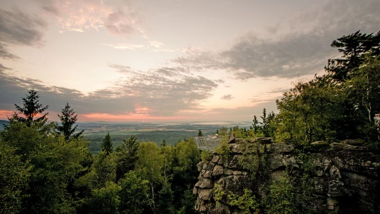 Almond stone, © Studio Kerschbaum Mandelstein viewpoint with a view of the wooded landscape at sunset.