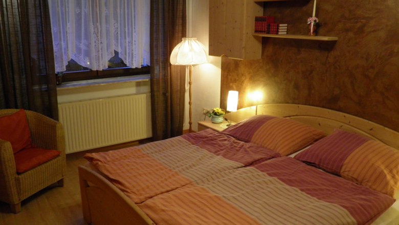 Bedroom, © Kesper Cozy bedroom with double bed, bedside lamps, bookshelf and armchair.