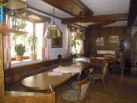 Private room Karl Mandl, © Familie Mandl A traditionally furnished room with wooden furniture, plants on the windowsill and hanging lamps.