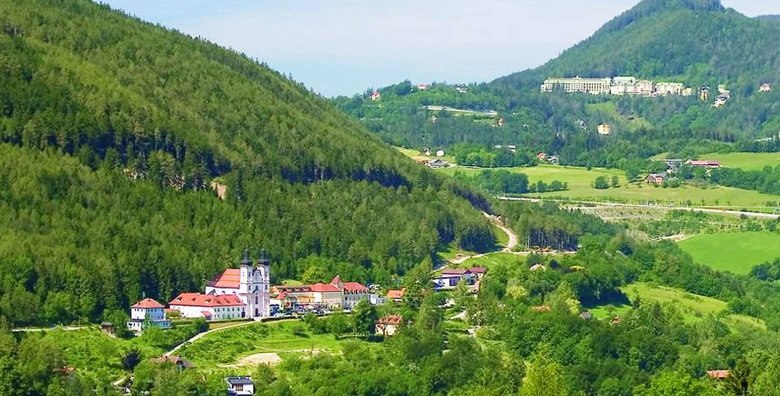 Maria Schutz in spring-summer, © Fam. Auer GmbH Landscape with church and green hills in the foreground.