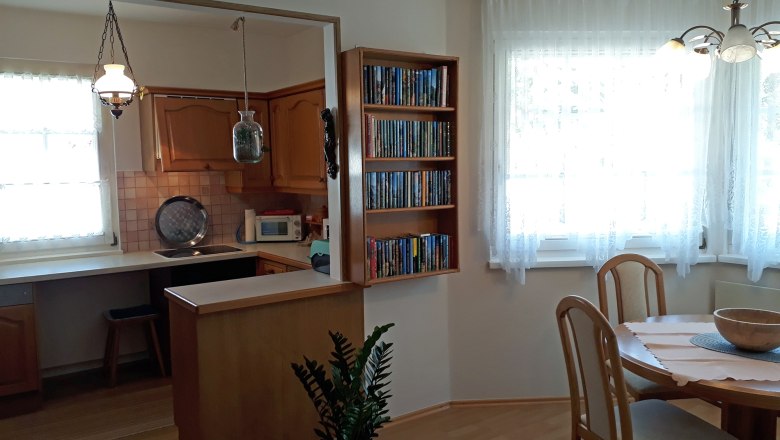 Kitchen, © Barbara Muck Cozy kitchen with wooden furniture, dining table and bookshelf.