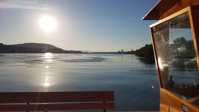 New Zille on the water, © Schiffsführerschule Ing. Karl Hell Sunset over a calm river with a wooden boat in the foreground.