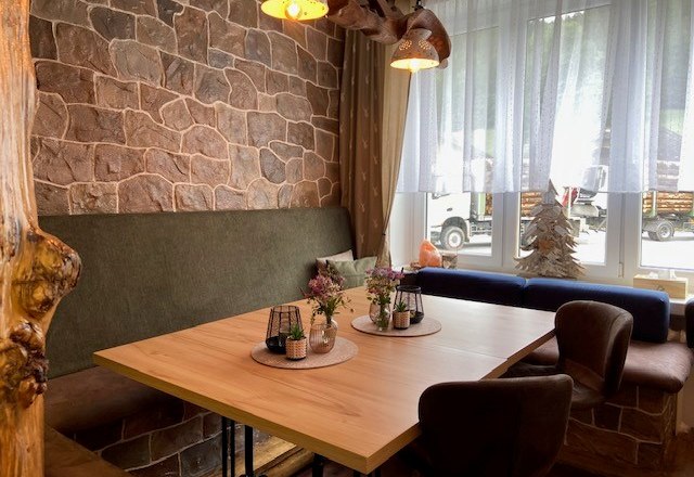 Comfortable seating in the farm store, © Wiener Alpen Cozy seating area in a farm store with wooden table, upholstered chairs and decorations on the table.