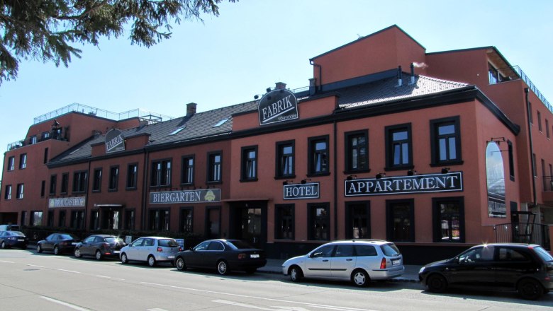 Hotel Braugasthof Fabrik, © Braugasthof Fabrik Exterior view of the Hotel Braugasthof Fabrik with parked cars in front of it.