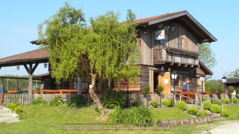 Bärndorfer huts, © Bärndorfer Hütte A rustic wooden hut with terrace and garden in the countryside, in sunny weather.