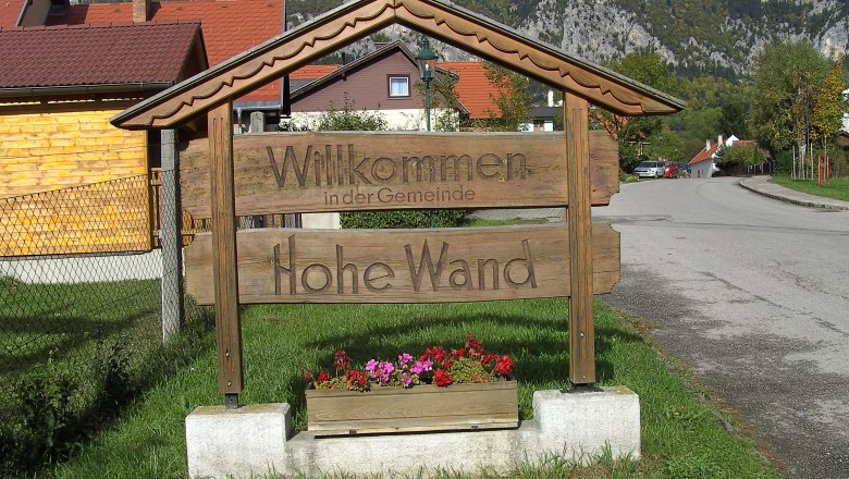 Welcome to the Hohe Wand Nature Park, © Stern Wooden sign with the inscription 'Welcome to the municipality of Hohe Wand' in front of a mountain landscape.