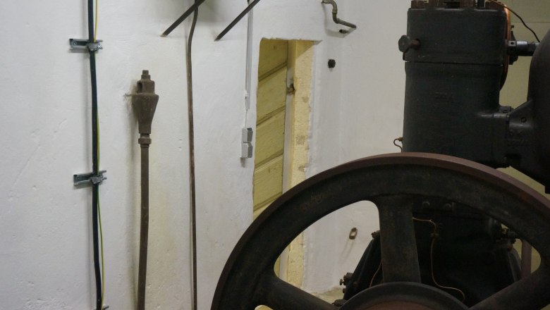 Motor, © K. Vyhnalek Old motor in a room with white walls and cables.