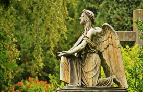 Cemetery, © gemeinfrei Angel statue in a cemetery, surrounded by green vegetation.