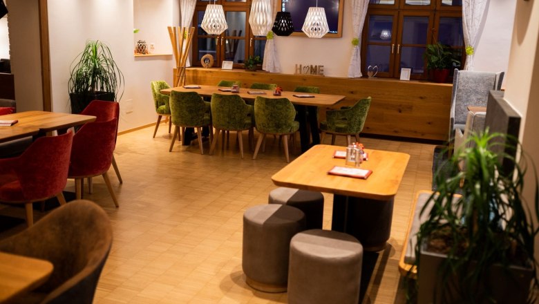 Koll Bistro Kirchschlag, © Koll GmbH Interior view of a cozy bistro with wooden tables, chairs and modern lighting.