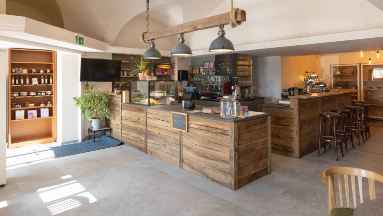 BREADLEY BISTRO, © Marek Safranek Interior view of a cozy café with wooden furniture and counter.