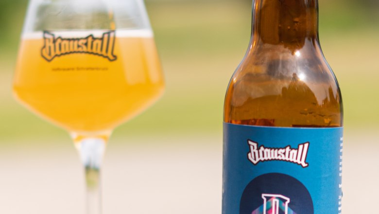 brewstable_brewday, © Hofbrauerei Braustall_Georg Schwameis A bottle of Braustall Pale Ale and a glass of beer on a table outside.