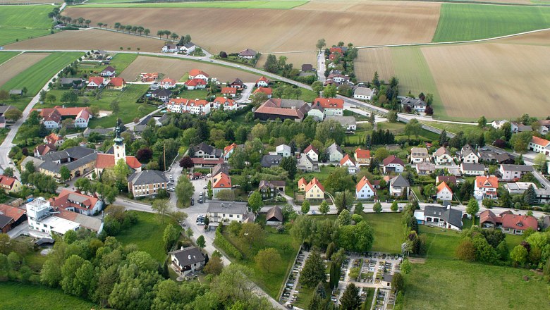 Flight recording, © Ferdinand Bertl Aerial view of a village with church, houses and fields.