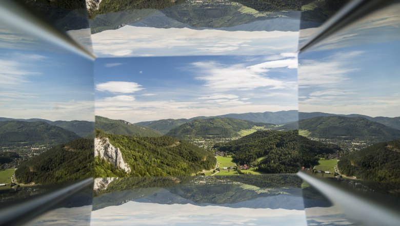 Viewpoint Hausstein, © Wiener Alpen, Foto: Franz Zwickl Reflection of a mountain landscape with blue sky and clouds.