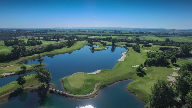 Flyover, © DCC Aerial view of a golf course with water hazards and green fairways.