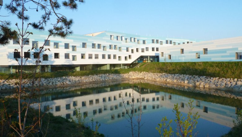BORG Deutsch-Wagram, © Werner Ertl Modern building with blue and white façade and pond in the foreground.