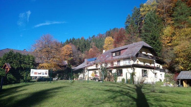 House view, © Familie Kellner A large house with a pitched roof in an autumnal forest landscape.