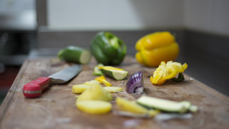 Alpen-Aktiv-Landgasthof zur Schubertlinde, © Patrick Haberler Vegetables and knives on a chopping board in a kitchen.