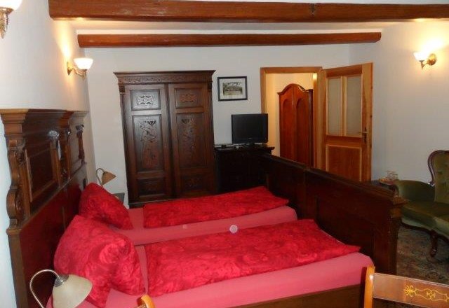 Double room Ried Klaus, © Familie Denk A traditionally furnished double room with two single beds, a wooden wardrobe and a small TV.