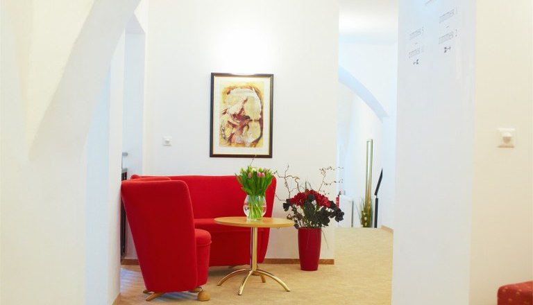 Foyer in front of rooms, © Rathauskeller Melk A bright foyer with red furniture and flowers.
